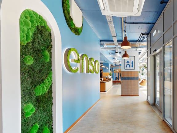 a green wall with the logo on it in a lobby