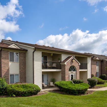 Apartment complex with a green lawn in front.