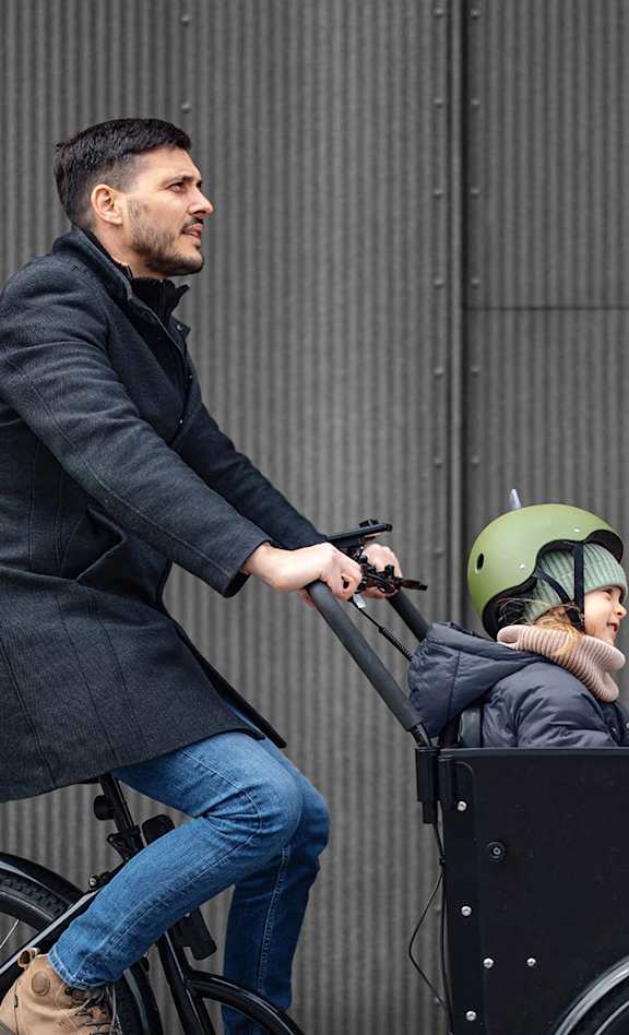 a man riding a bike with a child in a cart