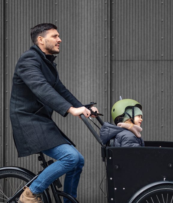 a man riding a bike with a child in a cart