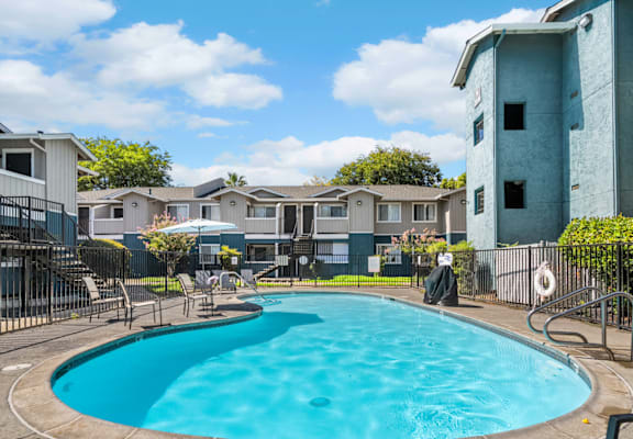 A swimming pool in a residential area with houses in the background.