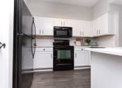 Thumbnail 35 of 40 - Modern kitchen with black appliances at Emblem Alpharetta, Alpharetta, Georgia