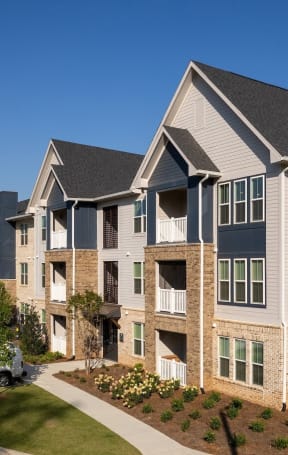 an exterior view of an apartment building with a parking lot