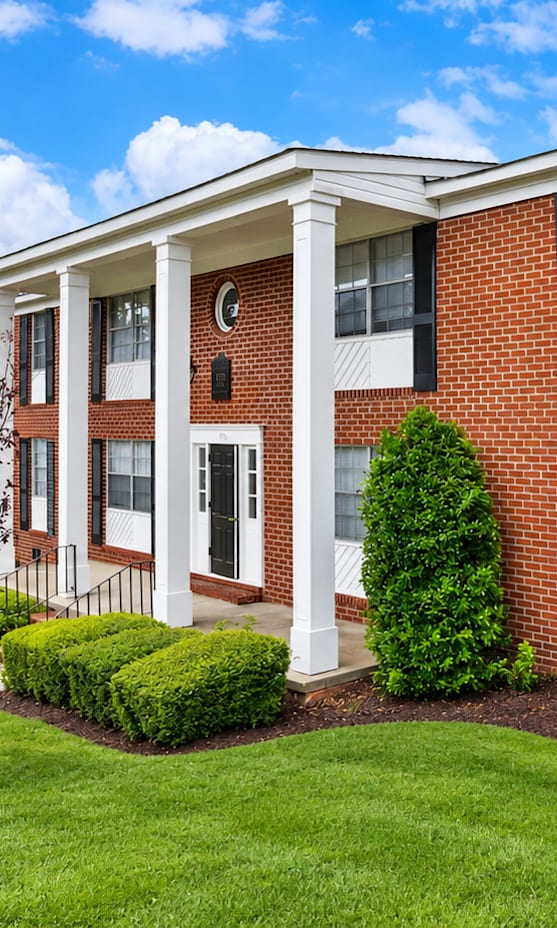 A red brick house with white trim and a porch.