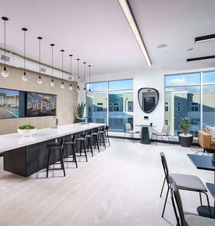 a dining room with a long table and chairs and a large window  at NoMa Apartments, California, 94596