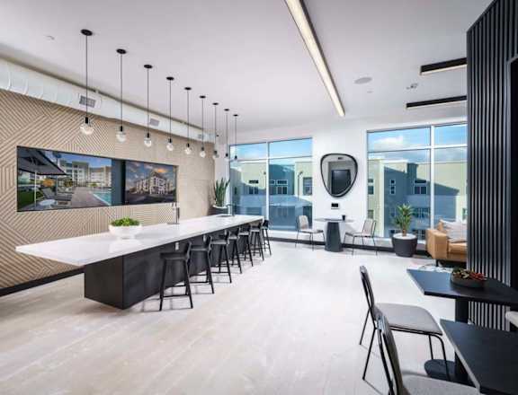 a dining room with a long table and chairs and a large window  at NoMa Apartments, California, 94596