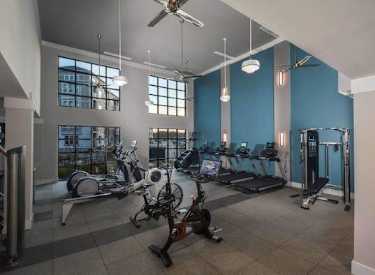 a gym with exercise equipment and windows in a building