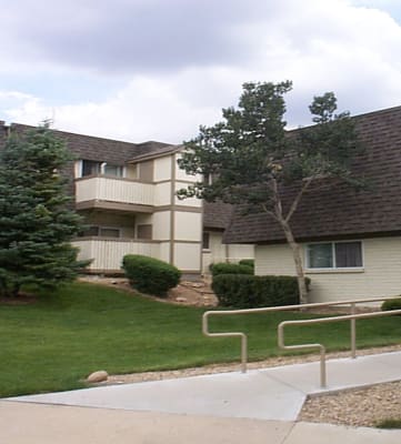 an apartment complex with a grassy area and trees  at Mountain Terrace, Colorado, 80031