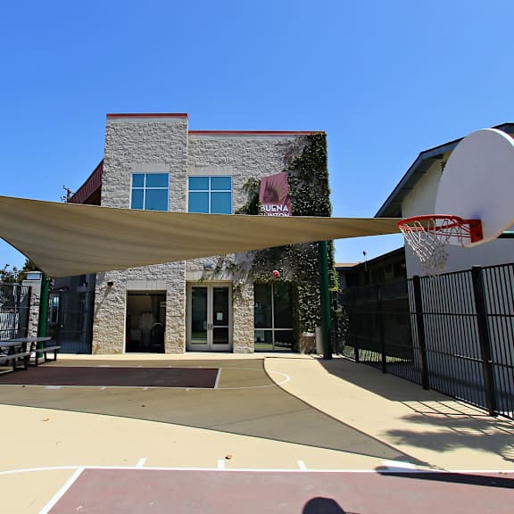 The front of the Mesa Vista Apartments building with a flag flying in the background.