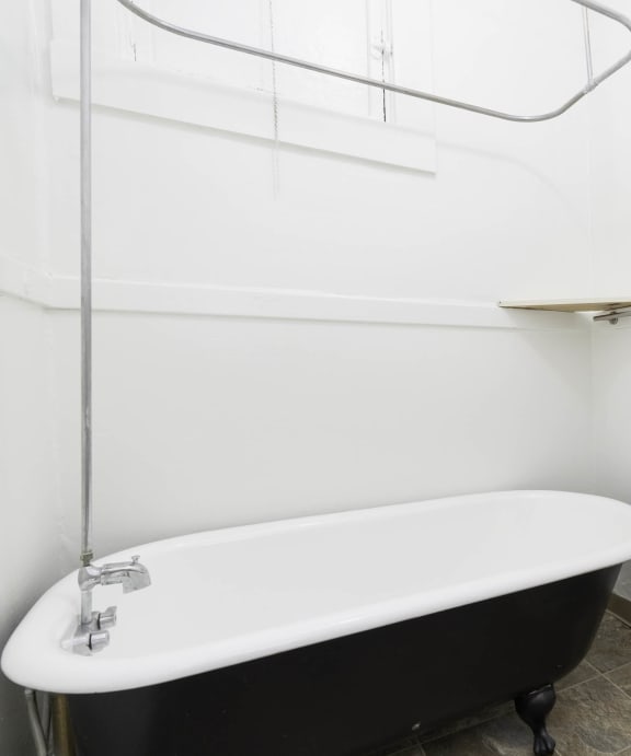 a white bathroom with a black bath tub and a sink at Clay & Tiffany, Portland, 97201