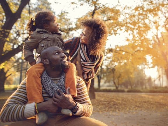 a man and woman with a child on their shoulders in a park at Overland Gardens, Landover, 20785