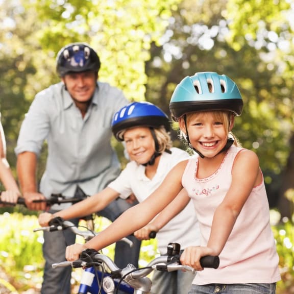 a family riding bikes on a bike trail with their child