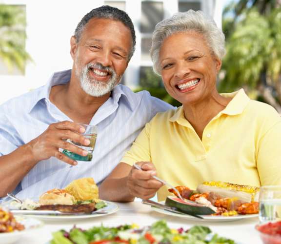 An older couple enjoying a meal together at a table.
