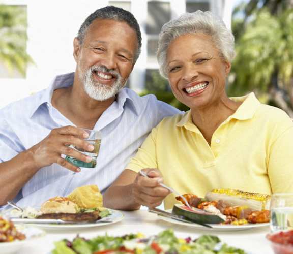 a man and a woman sitting at a table eating food