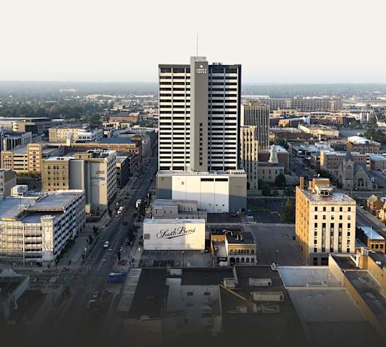 A cityscape with a tall building in the center and a sign that reads "St. Regis".