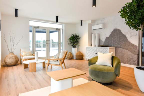 A living room with a green armchair and a white couch.