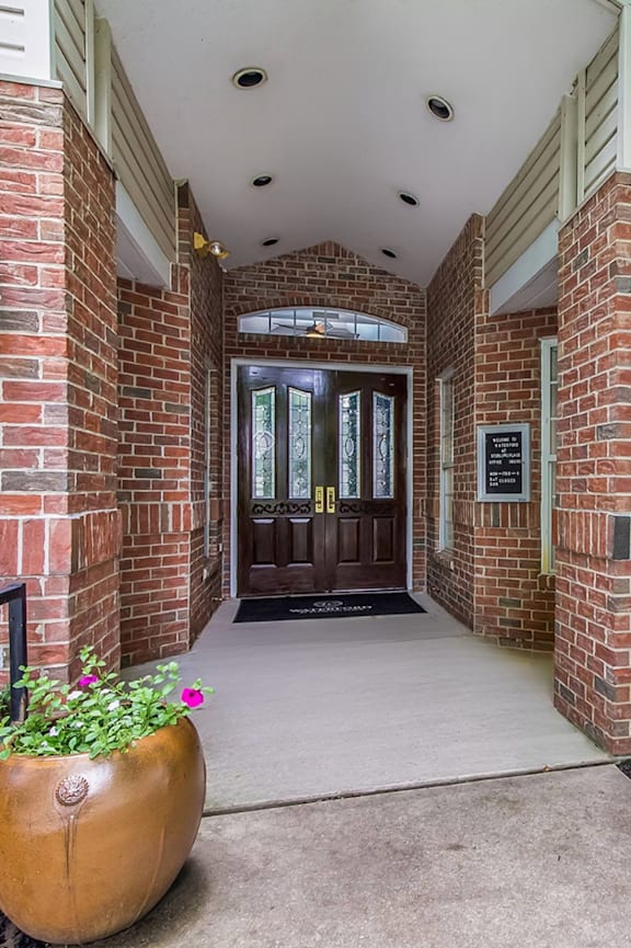 a view of the front entrance of a brick building with a wooden door