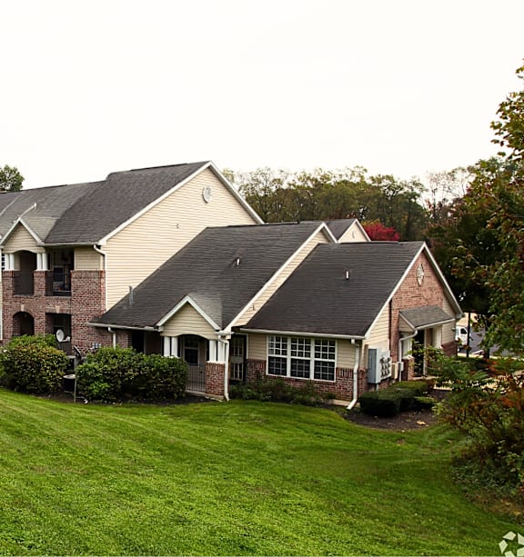 A row of houses with green lawns in front.