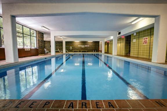 A gym with a variety of equipment including treadmills, weights, and exercise machines.