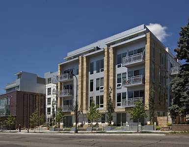 A modern apartment building with balconies and a clear blue sky.