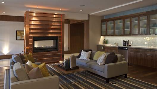 A modern living room with a fireplace and a striped rug.