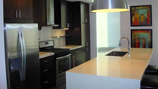 A modern kitchen with a refrigerator, stove, and sink.