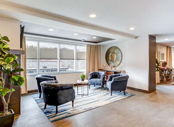 A living room with a large window and a view of a parking lot.