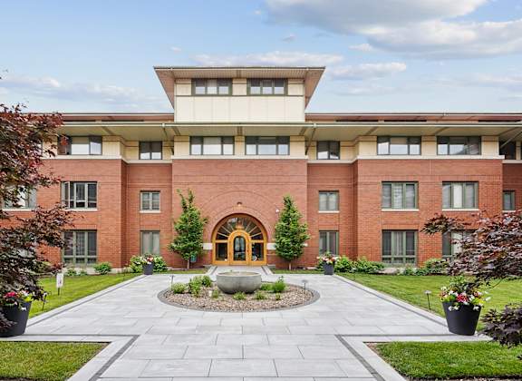 A red brick building with a circular walkway in front.