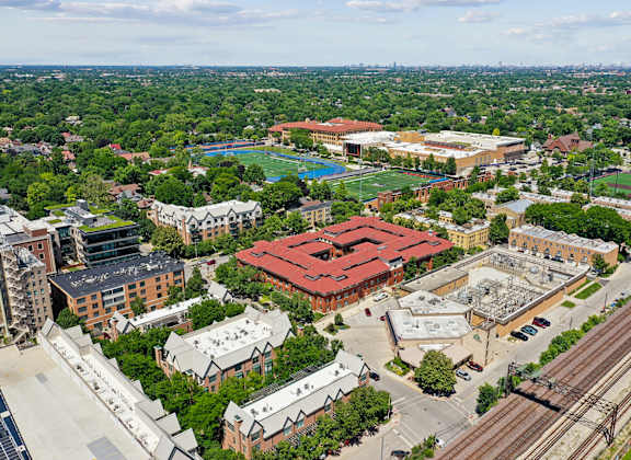 A view of a campus with a red roofed building in the center.