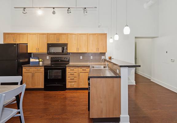 A kitchen with wooden cabinets and black appliances.