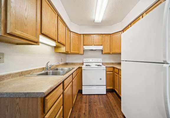A kitchen with wooden cabinets and a white refrigerator.