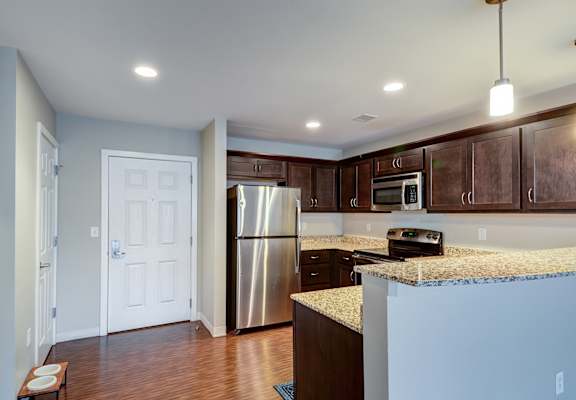 A kitchen with a stainless steel refrigerator and microwave.
