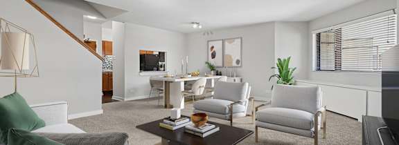 A living room with a grey couch and a green pillow.