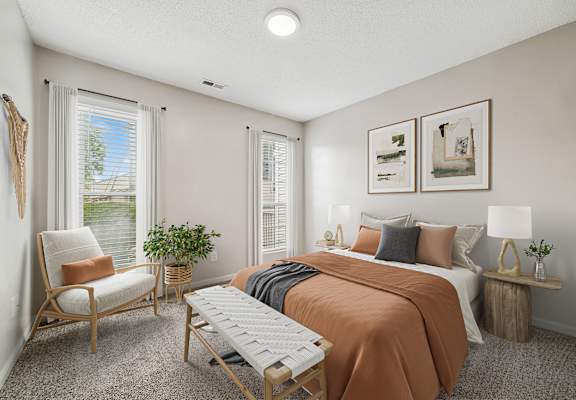 A bedroom with a bed, chair, and window.