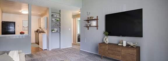 A room with a carpeted floor and a sliding glass door leading to a balcony.