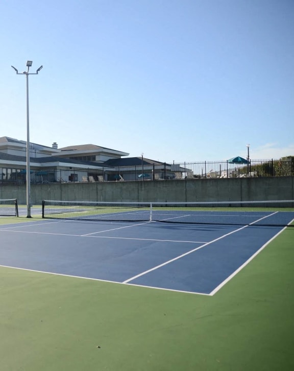 a tennis court with a building in the background