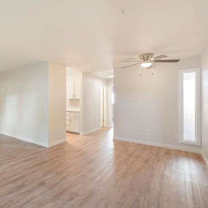 A large room with hardwood floors and a ceiling fan