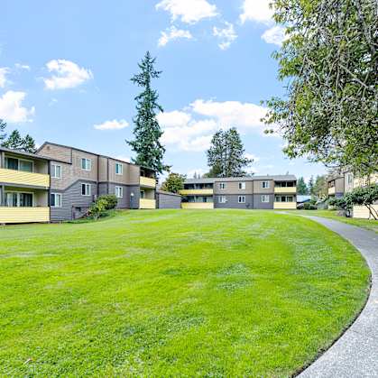 A grassy area in front of apartment buildings.