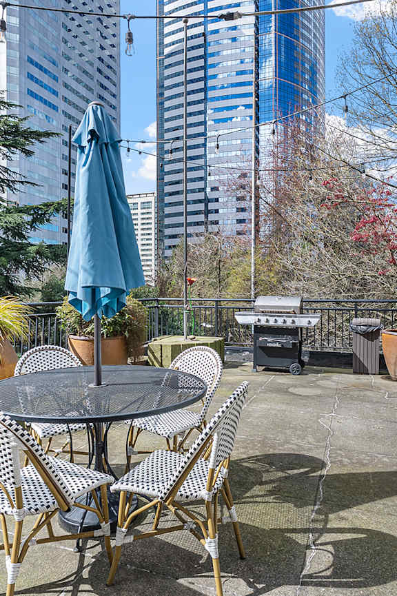 A small pool in a backyard with a house in the background. at The Exeter Apartments, Washington