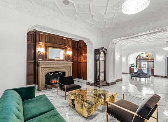A living room with a fireplace and a green sofa. at The Exeter Apartments, Washington