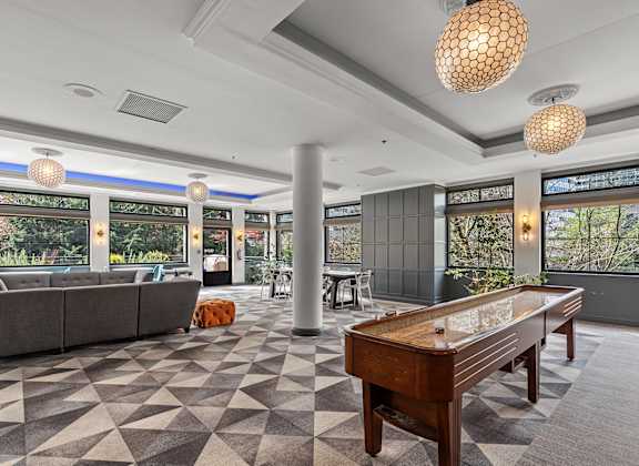 A game table is in the middle of a room with a checkered floor. at The Exeter Apartments, Washington