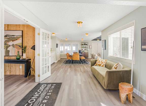 A large room with a couch, chairs, and a rug that says Concord Crossing.