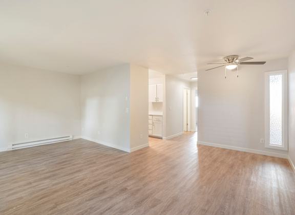 A large room with hardwood floors and a ceiling fan
