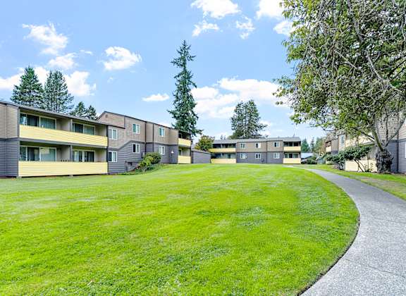 A grassy area in front of apartment buildings.