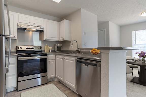 A modern kitchen with stainless steel appliances and white cabinets.