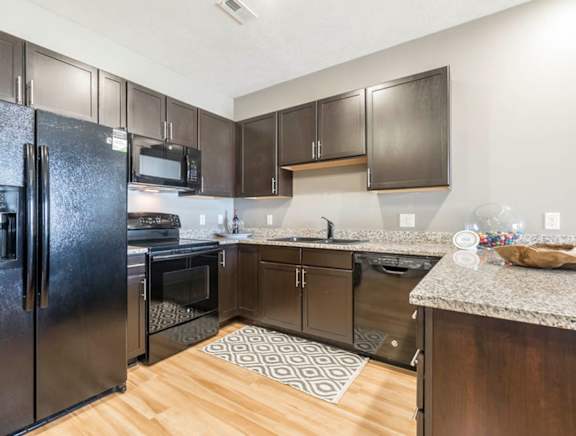 a large kitchen with stainless steel appliances and granite counter tops