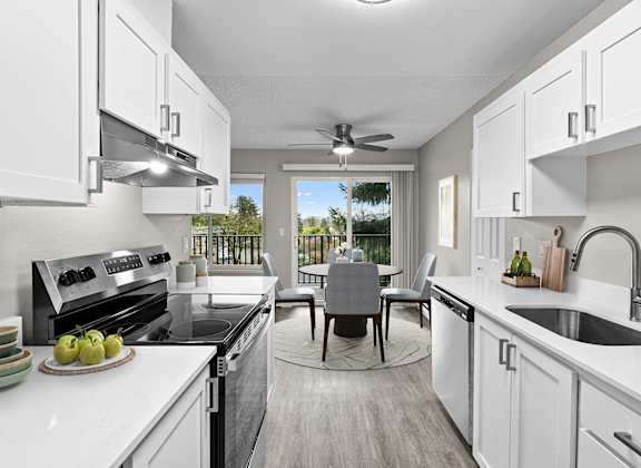 A modern kitchen with a dining table and chairs in the middle.
