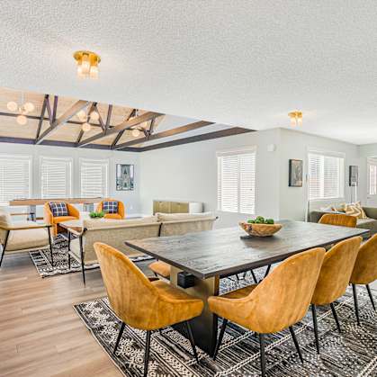 A large room with a table and a room with a shuffleboard table in the background