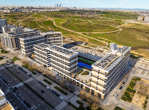 an aerial view of a city with buildings and an open field