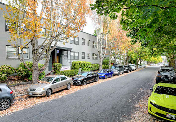 Cars parked on a street in front of a building.